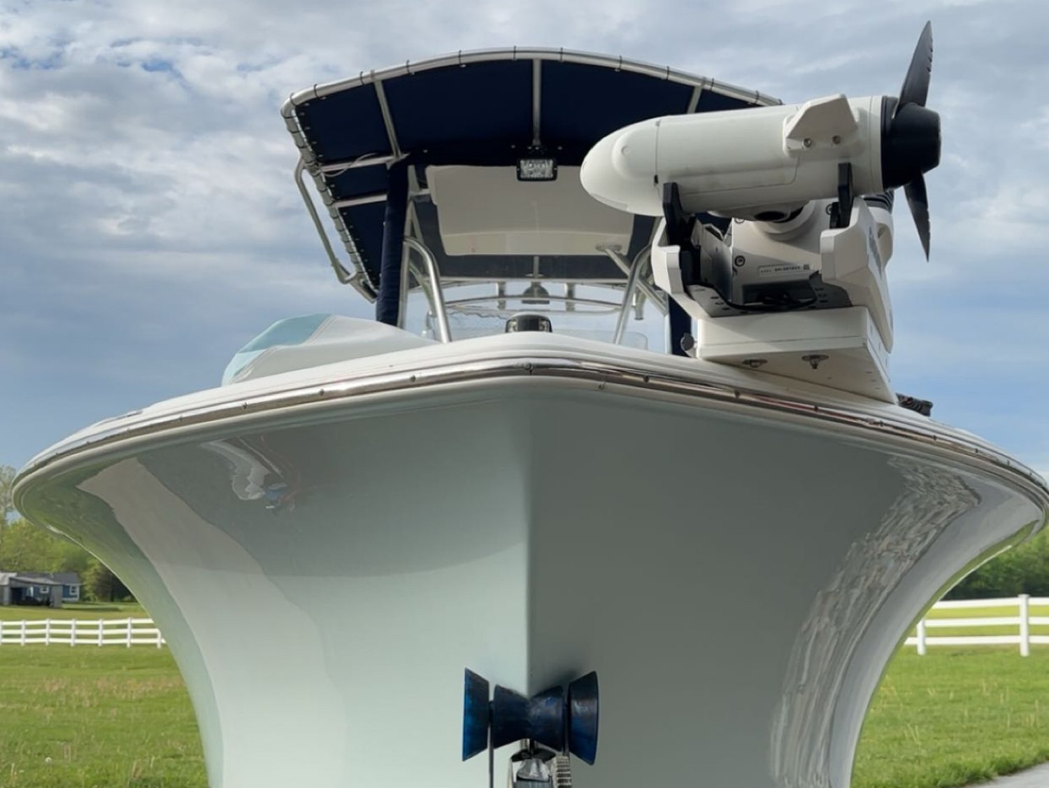Center console boat with a freshly polished gel coat hull, the finish mirroring the sky and treeline